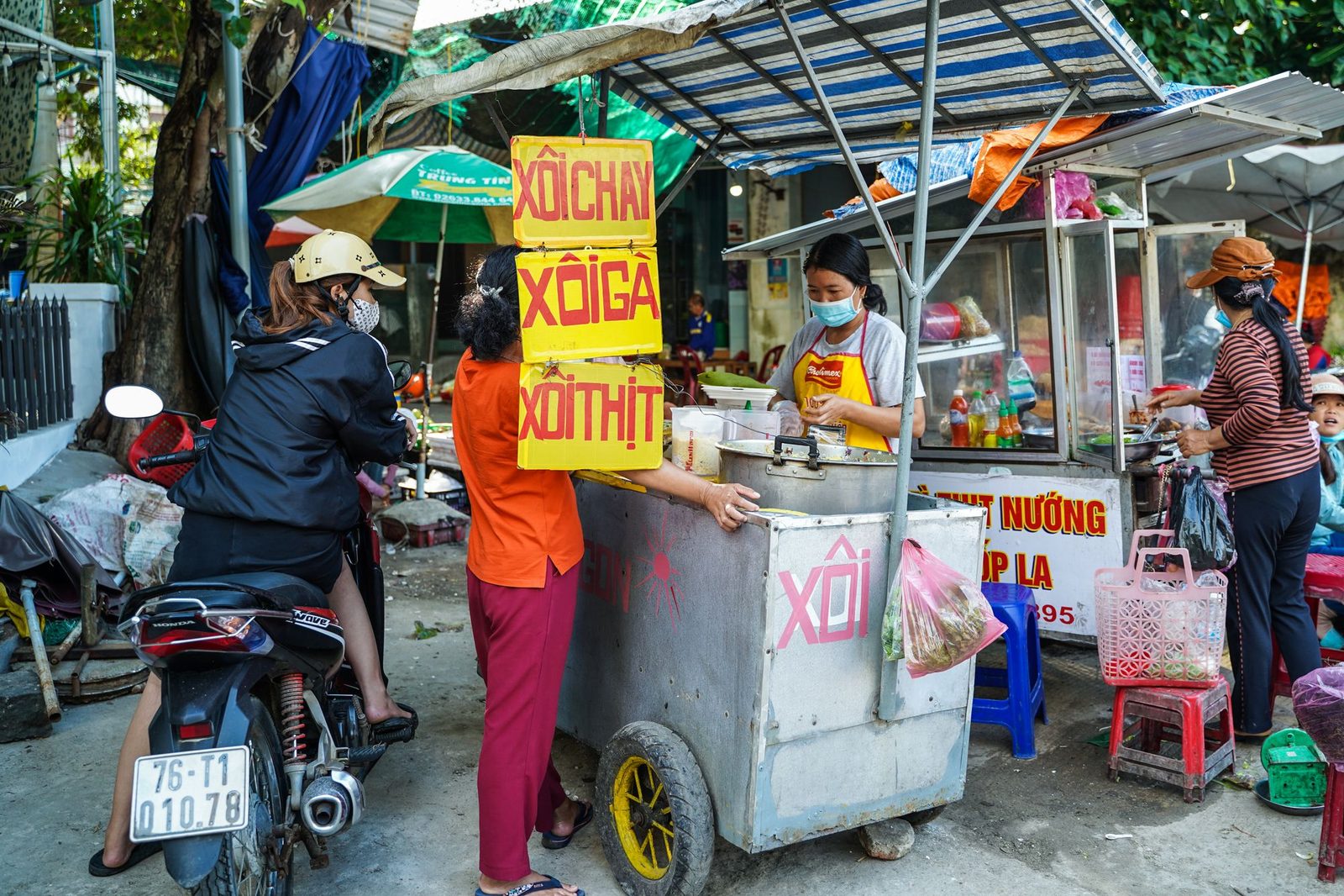 Người bán hàng rong và khách bên xe xôi vỉa hè